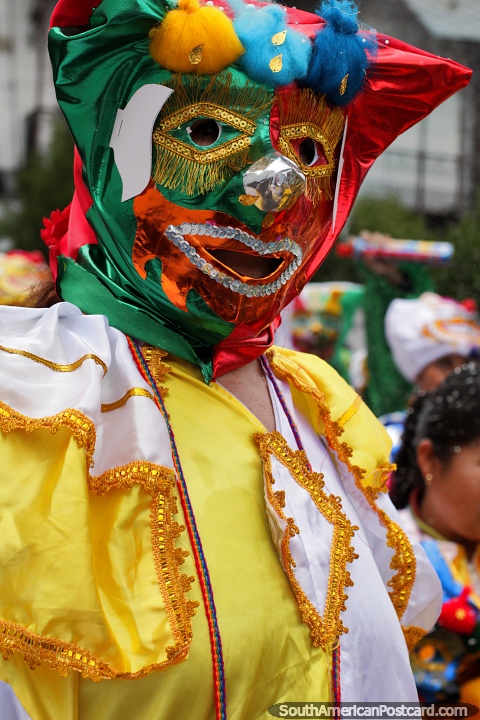 Face mask of red and green, outfit of yellow and white, Sucre carnival. (480x720px). Bolivia, South America.
