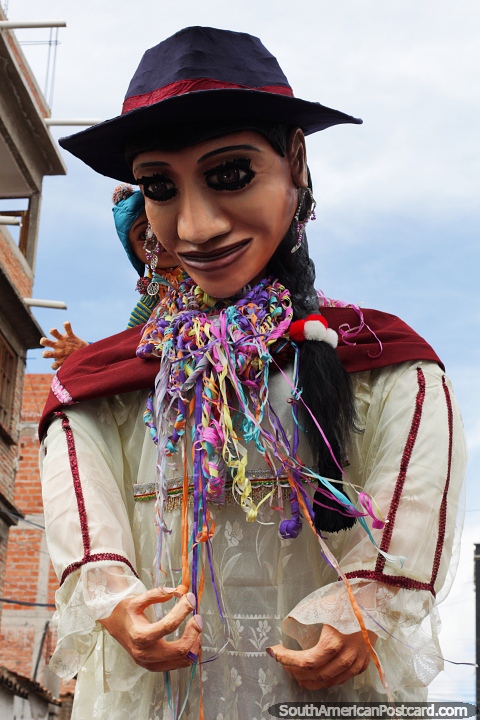 High above the crowds, a huge boneco as they call them in Brazil, carnival in Sucre. (480x720px). Bolivia, South America.