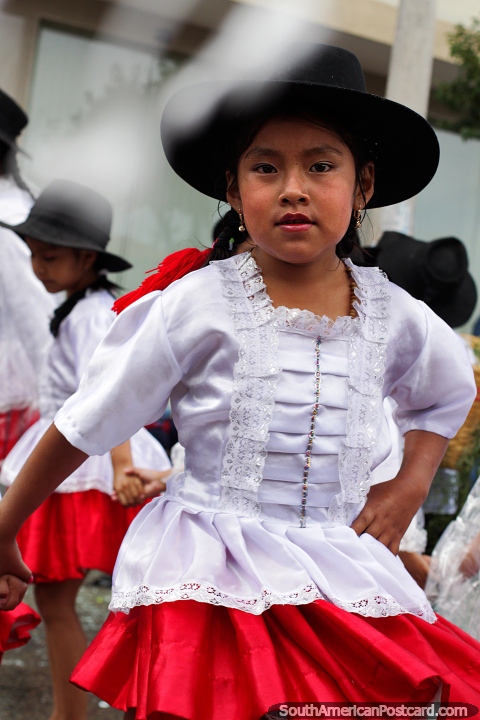 Young girl in traditional clothing, red and white with a black hat, Sucre carnival. (480x720px). Bolivia, South America.