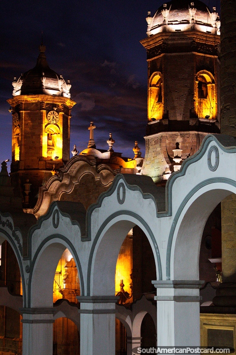 A catedral ilumina-se com a luz com torres acima dos arcos da praça pública em Potosi. (480x720px). Bolívia, América do Sul.