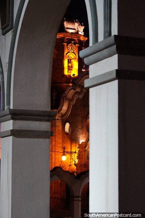 Torre de catedral com relógio, luzes a noite, entre os arcos em Potosi. (480x720px). Bolívia, América do Sul.