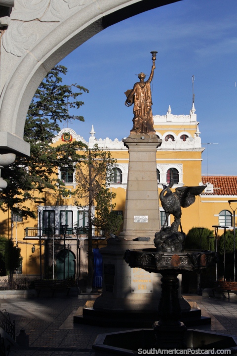 Estátua dourada, fonte preta, arco cinza e edifïcio de governo amarelo em Potosi, praça pública principal. (480x720px). Bolívia, América do Sul.