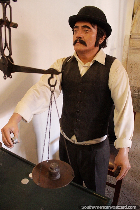 Man weighing coins, part of the tour of the famous coin museum in Potosi. (480x720px). Bolivia, South America.