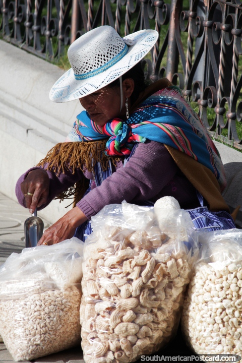 A mulher vende refeições leves de tipo do milho para pipoca na praça pública em Potosi. (480x720px). Bolívia, América do Sul.