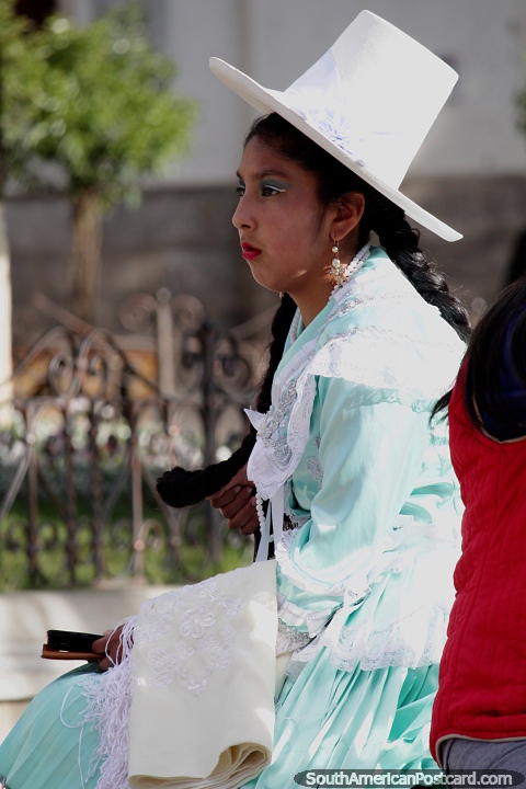 La mujer lleva un alto sombrero de copa blanco y un vestido verde claro, un evento en Potos. (480x720px). Bolivia, Sudamerica.