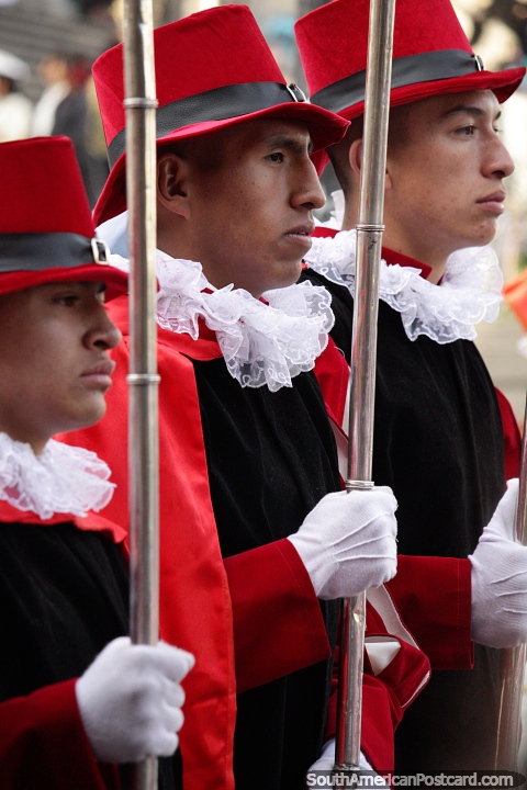 Os homens de rainhas vestiram-se no vermelho com chapéus para combinar, marchando do acordo em Potosi. (480x720px). Bolívia, América do Sul.