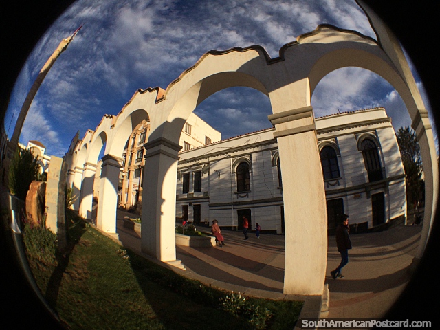 Plaza 6th of August in Potosi with many arches all around and a tall monument. (640x480px). Bolivia, South America.