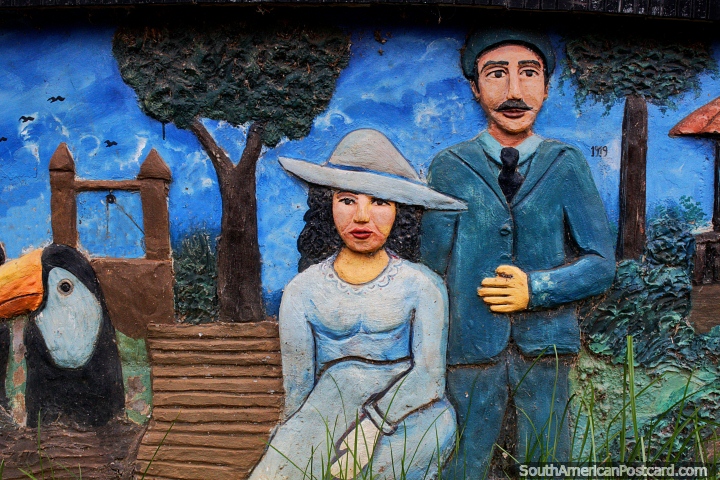 Homem e mulher no parque com uma arara, escultura de concreto na praça pública em Riberalta. (720x480px). Bolívia, América do Sul.