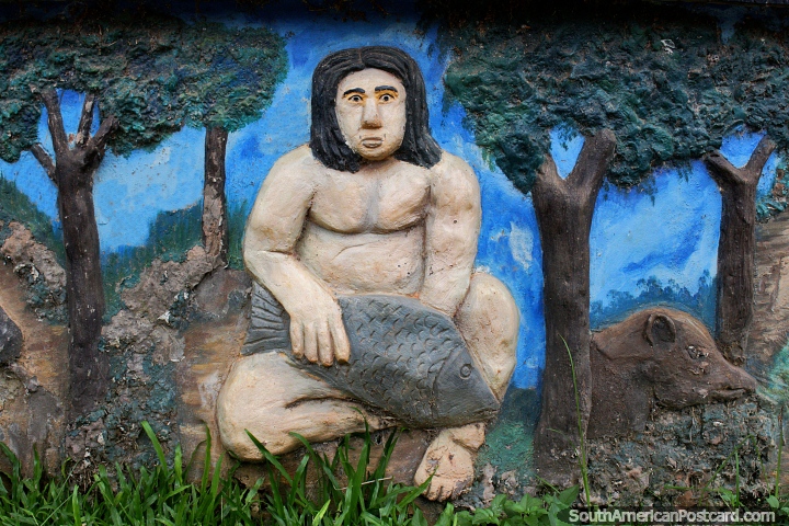 Homem indïgena com um peixe e porco, escultura concreta na praça pública em Riberalta. (720x480px). Bolívia, América do Sul.
