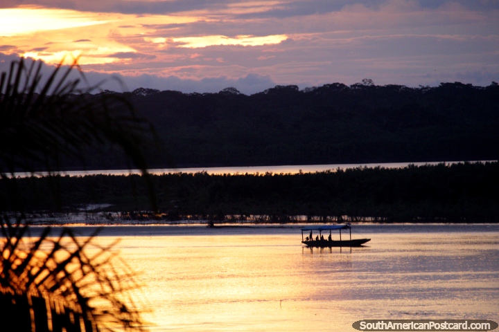 Boat travels along the river in Riberalta at sunset. (720x480px). Bolivia, South America.