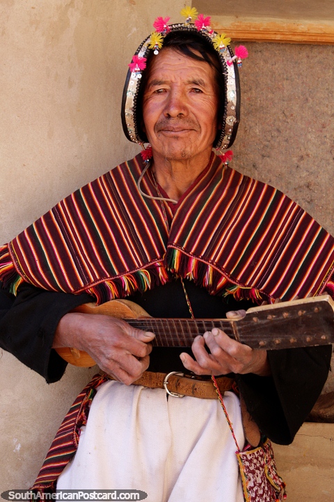 Tocando un instrumento de cuerda con 10 cuerdas, un hombre indígena de Puka-Puka. (480x720px). Bolivia, Sudamerica.