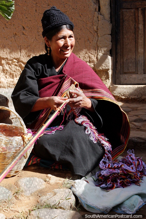 A mulher de Puka-Puka tece a roupa tradicional na sua aldeia e comunidade. (480x720px). Bolívia, América do Sul.