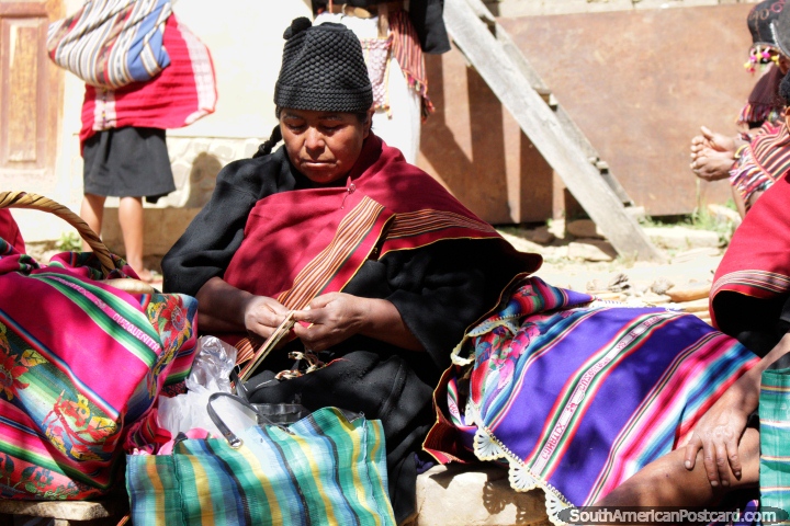 Mujer en ropa tradicional negra y roja tejiendo en el pueblo de Puka-Puka, cerca de Sucre. (720x480px). Bolivia, Sudamerica.