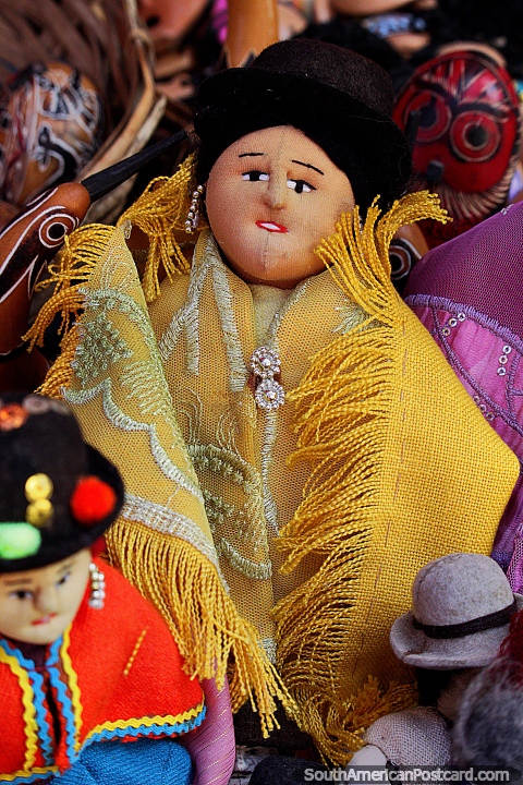 Senhora de chapéu boneca, usa um xale amarelo, lembranças no mercado de Tarabuco. (480x720px). Bolívia, América do Sul.