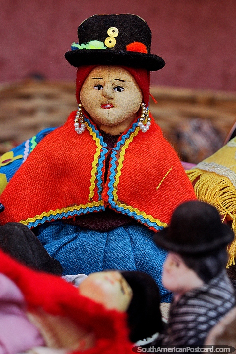 Mueca de sombrero con un chal rojo y vestido azul, comienza una coleccin en el mercado de Tarabuco. (480x720px). Bolivia, Sudamerica.