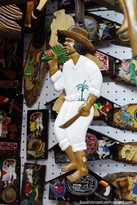 El hombre tiene un cuchillo y una palmera, artesanas de madera y en venta en Santa Cruz. (480x720px). Bolivia, Sudamerica.