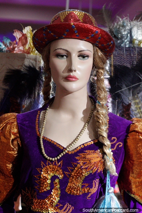 Caporal costume from 1990, female in purple and a red hat, Anthropological Museum in Oruro. (480x720px). Bolivia, South America.