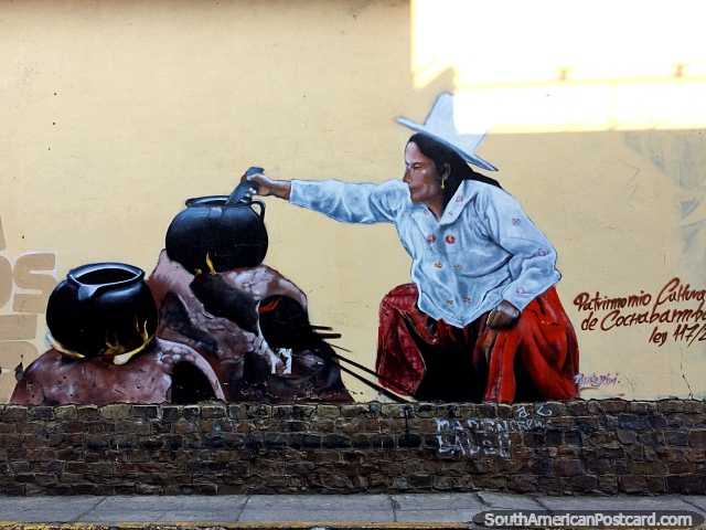 Una mujer cocina comida en ollas en un fuego abierto, vestido rojo, sombrero blanco, arte callejero en Cochabamba. (640x480px). Bolivia, Sudamerica.