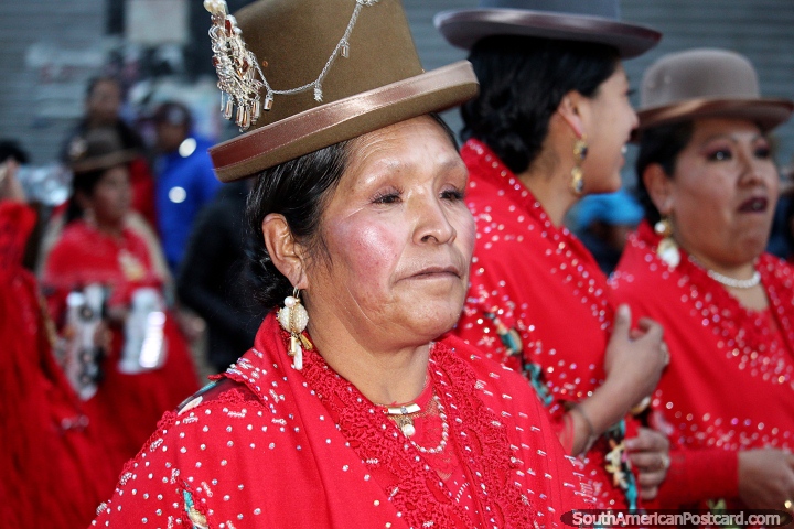 Vestida de rojo con grandes aretes, una mujer con sombrero boliviano en el desfile de El Gran Poder en La Paz. (720x480px). Bolivia, Sudamerica.