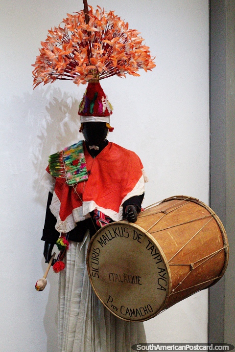 Musician in traditional clothing with a big drum, from the Camacho province beside Lake Titicaca, model at Musef museum, La Paz. (480x720px). Bolivia, South America.
