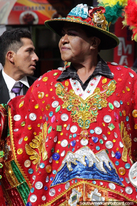 An outfit of red featuring snowy mountains, fine costumes at the El Gran Poder parade in La Paz. (480x720px). Bolivia, South America.
