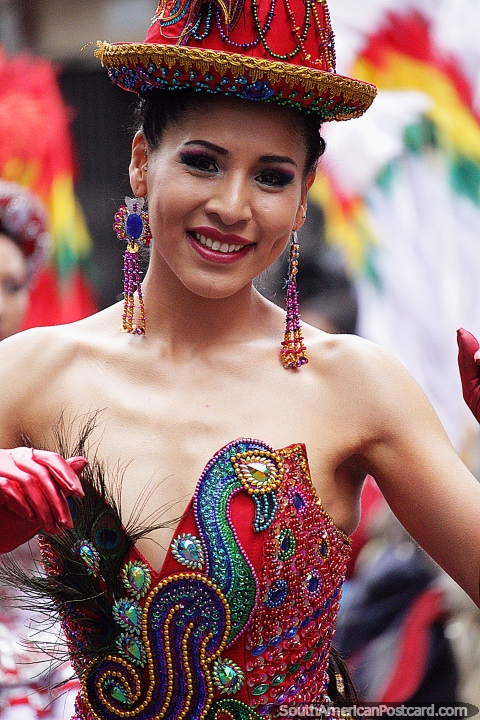 With big earrings and embroidered dress, this female dancer has a big smile, El Gran Poder festival, La Paz. (480x720px). Bolivia, South America.
