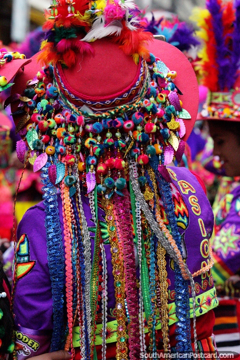 Technicolor hat with 100 felt balls in bright colors, feathers at the top, El Gran Poder festival, La Paz. (480x720px). Bolivia, South America.