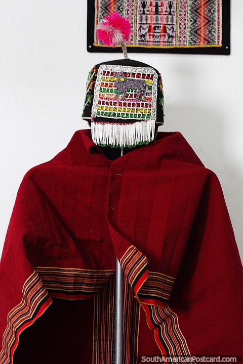 Red shawl and colorful head wear on display at Cetur, the textile arts museum in Sucre. (480x720px). Bolivia, South America.