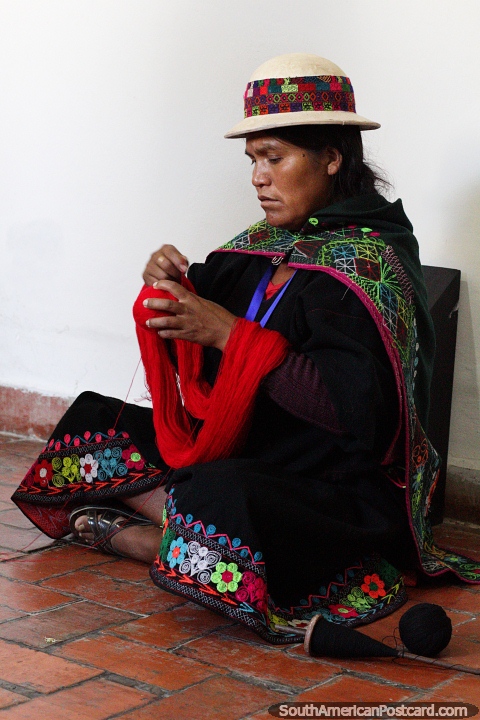 Mujer en ropa tradicional tejiendo con lana roja en el museo de arte textil (Cetur) en Sucre. (480x720px). Bolivia, Sudamerica.
