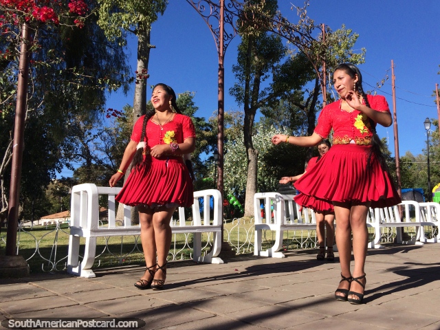 Seoras vestidas de rojo, bailarines actan en el Parque Bolvar, un hermoso lugar en Sucre, con grandes sonrisas. (640x480px). Bolivia, Sudamerica.
