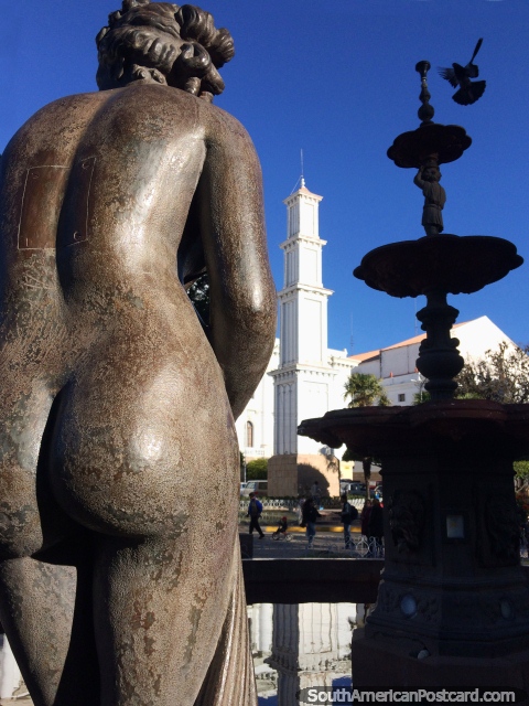 Naked bronze statue, the fountain with flying bird and the white Obelisk tower at Bolivar Park in Sucre. (480x640px). Bolivia, South America.