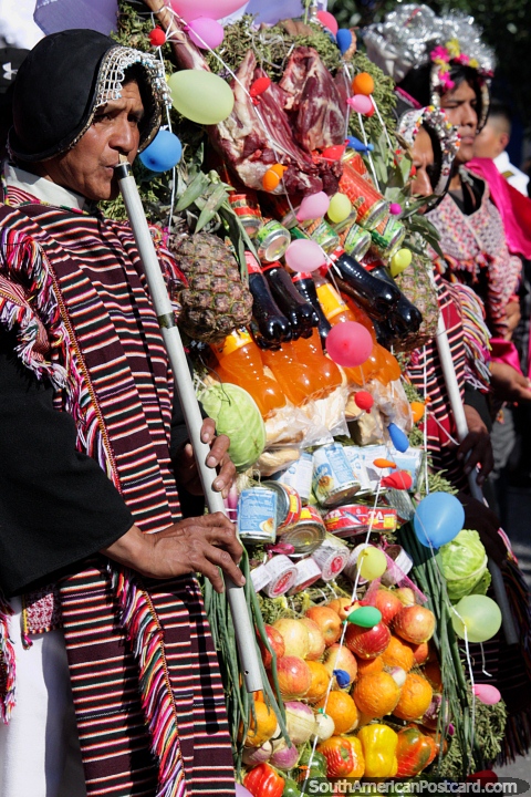 Ofrendas de alimentos y bebidas, hombres con vestimentas tradicionales que soplan traquea, desfile de El Gran Poder en Sucre. (480x720px). Bolivia, Sudamerica.