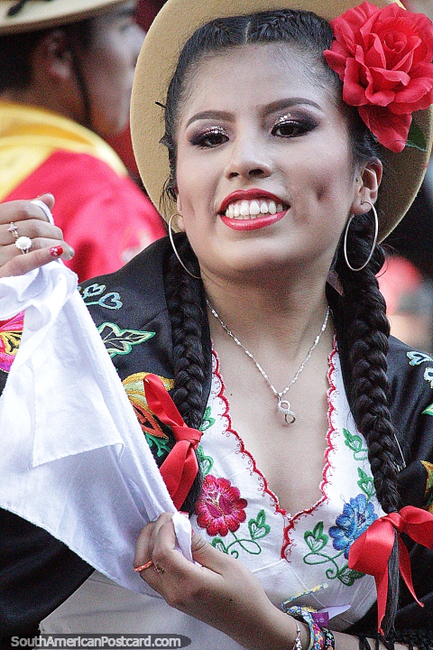 Seora con una gran sonrisa y flor roja en el pelo, desfile de El Gran Poder en Sucre. (480x720px). Bolivia, Sudamerica.
