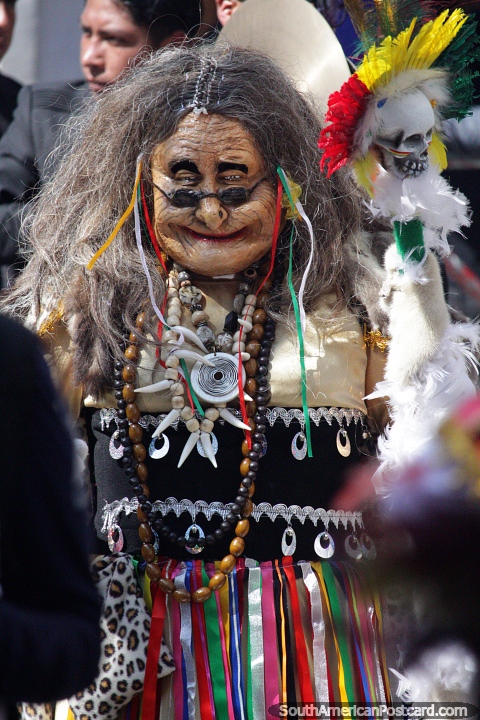 Old man with long grey hair, spectacles and many necklaces of teeth and beads, weird and wonderful costume at El Gran Poder, Sucre. (480x720px). Bolivia, South America.