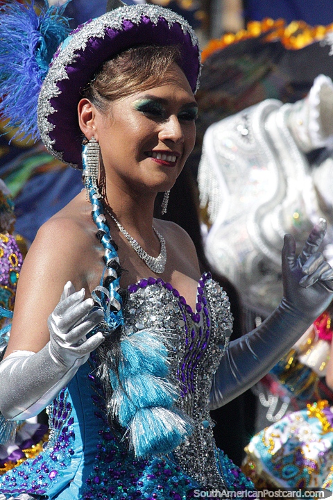 Con guantes plateados, un sombrero morado y un vestido verde azulado, esta bailarina disfruta del desfile de El Gran Poder en Sucre. (480x720px). Bolivia, Sudamerica.