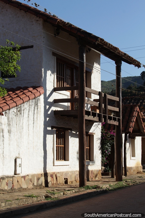 Nice house with a wooden balcony held up by 2 poles in Samaipata. (480x720px). Bolivia, South America.