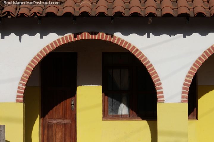 Prdio com arcos de tijolo, telhado de telha, portas e janelas de madeira e pintado de amarelo em San Ignacio de Velasco. (720x480px). Bolvia, Amrica do Sul.