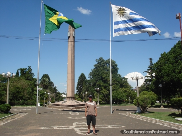 Standing on the line separating Brazil and Uruguay! The times on the 2 clocks are 1 hour apart. (640x480px). Brazil, South America.