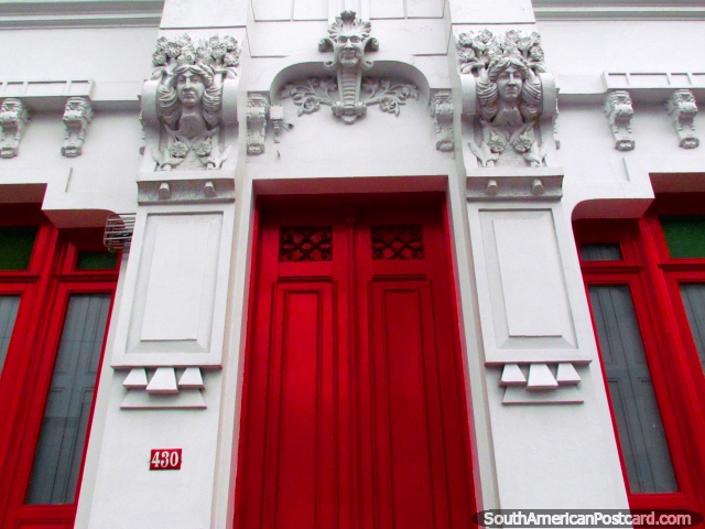 Caras en la cima de una puerta roja, la fachada de un edificio histrico en Rio Grande. (640x480px). Brasil, Sudamerica.