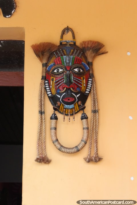 Uma máscara indïgena feita de madeira e corda em uma entrada de uma casa em Santarem. (480x720px). Brasil, América do Sul.