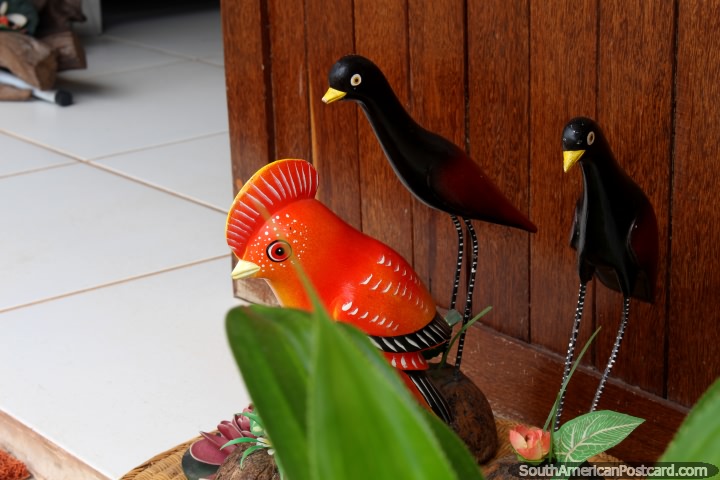 Un ave de color naranja y 2 pjaros negros, hecho de madera a la venta en una tienda de arte en Alter do Chao cerca de Santarem. (720x480px). Brasil, Sudamerica.