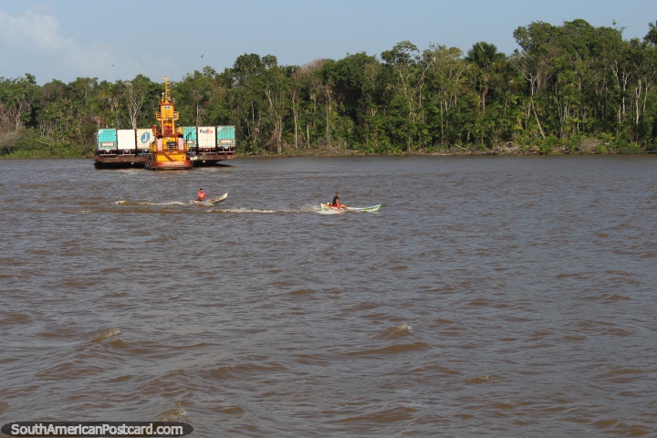 2 canoas motorizadas dirigem claro de uma enorme chata no rio, ao oeste de Belém. (720x480px). Brasil, América do Sul.