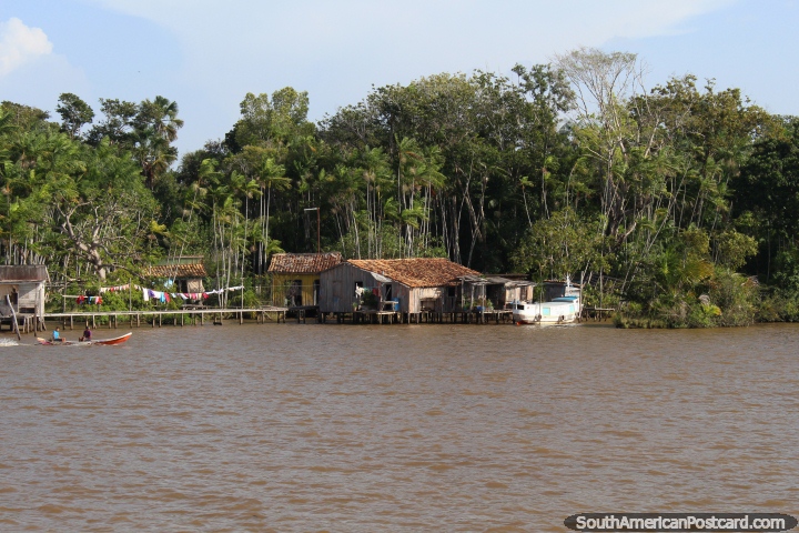 A riverside Amazon community, washing on the line, canoe passes, west of Belem. (720x480px). Brazil, South America.