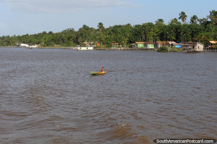 A woman in a canoe on the river in front of her community in the Amazon, west of Belem. (720x480px). Brazil, South America.