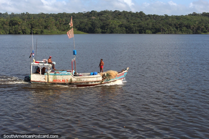 O barco de pesca viaja ao longo do Rio Oyapock em Oiapoque, visão do Brasil a Guiana Francesa. (720x480px). Brasil, América do Sul.