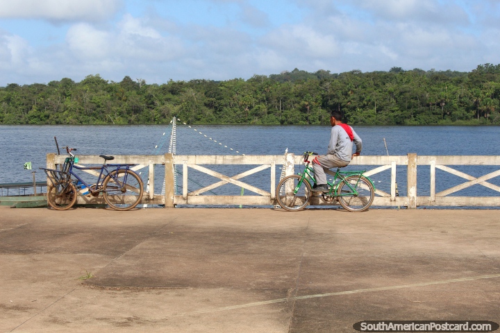 El hombre en una bicicleta disfrutando de vistas del Río Oyapock en Oiapoque. (720x480px). Brasil, Sudamerica.