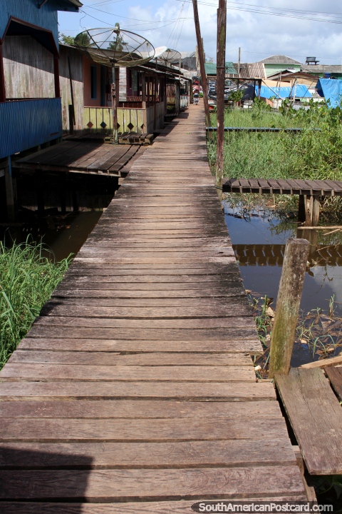 Houses accessed by a boardwalk above the river at the far end of Oiapoque. (480x720px). Brazil, South America.