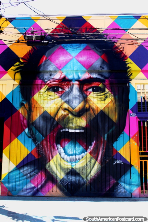 Man yells from a checkered wall, a bright mural in the street in Vila Madalena, Sao Paulo. (480x720px). Brazil, South America.