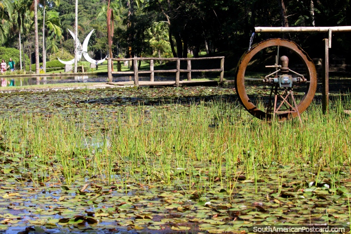 Water wheel and a distant white sculpture at the Sao Paulo Botanical Gardens. (720x480px). Brazil, South America.