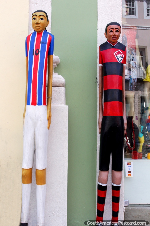 A pair of tall skinny soccer players in uniforms, crafts made of wood in Salvador. (480x720px). Brazil, South America.